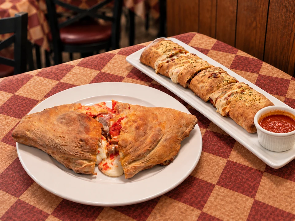 Calzone and Stromboli Roll together on Gumba’s checkered table. AI-assisted composite based on restaurant references.